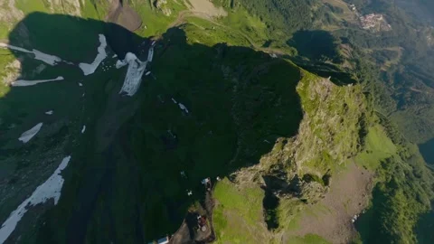 FPV sport drone dynamic dive shot close natural rock sunlight valley green grass Stock Footage 256023923