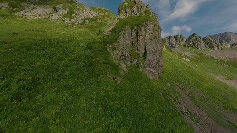 FPV sport drone flying up on mountains rocky top ranges green grass Stock Footage 330057052