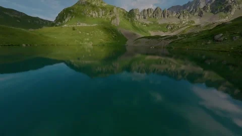 FPV sport drone flying over mountain lake crystal transparent water Stock Footage 330057013