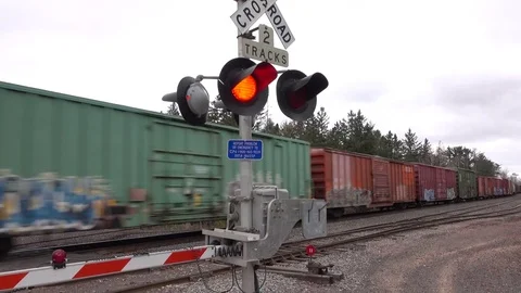 FPV: Standing behind the gates at the railroad crossing watching freight train Stock Footage 76014952