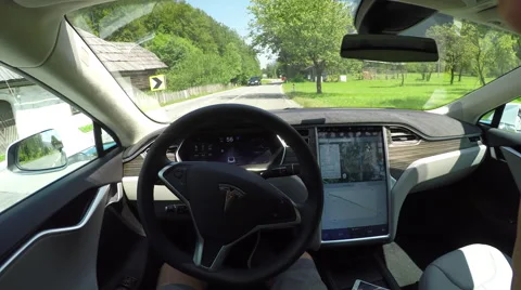 FPV: Tesla electric car self driving through green valley on local road Stock Footage 67220845