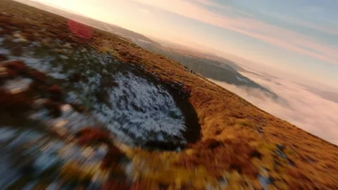 FPV view of valley inversion in the distance with beautiful golden colours on a Stock-Footage 231063207