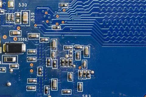 A fragment of a blue computer board with capacitors Stock Photos