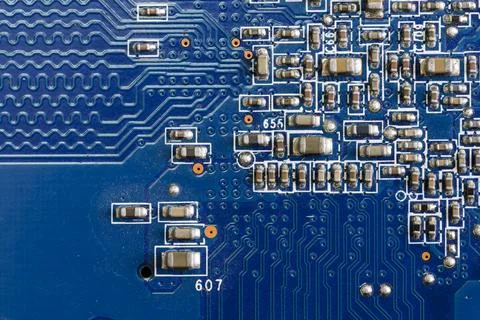 A fragment of a blue computer board with capacitors Foto stock