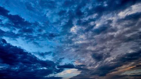 Fragment of a blue sky with white clouds. Summer beautiful sunny day. Moving  Stock Photos