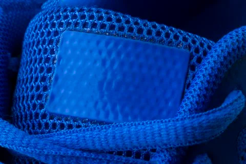 Fragment of a blue sneaker with drawstring macro.Sneaker texture Stock Photos