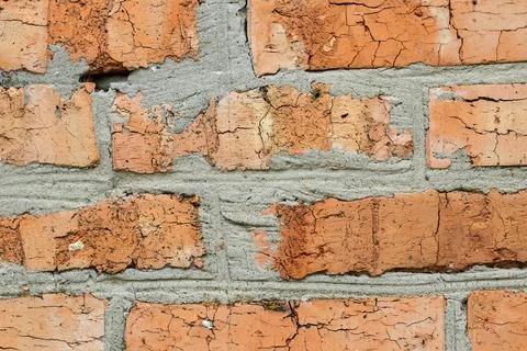 Fragment of a brick wall with cracks.Destruction of bricks under the influenc Stock Photos