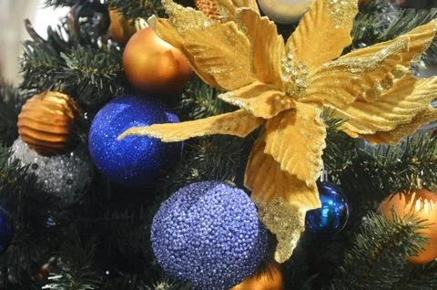 Fragment of a Christmas tree decorated with blue and gold balls, festive garl Stock Photos