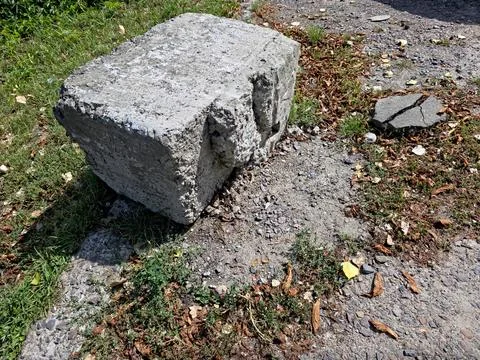 Fragment of Concrete Support Rests Upon Earth and Grass in a Forgotten Place Stock Photos