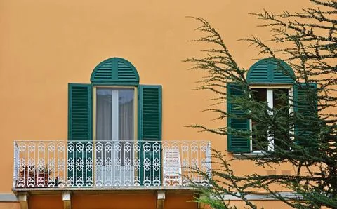 A fragment of the facade of a house with a white openwork metal balcony in sq Stock Photos