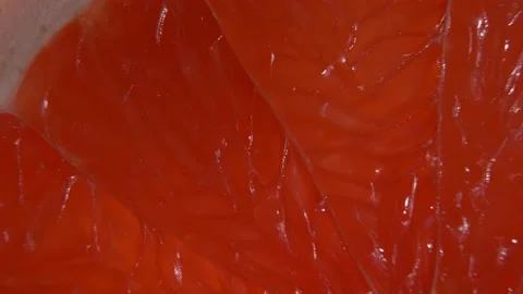 A fragment of grapefruit close-up on a black background. Organic fruit. Видео 147132985