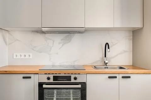 Fragment of a kitchen in gray solid colors with comfortable wall cabinets and 库存照片