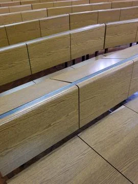 Fragment of  lecture hall with empty rows of wooden desks Stock Photos