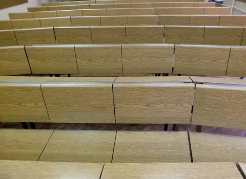 Fragment of  lecture hall with empty rows of wooden desks Stock Photos