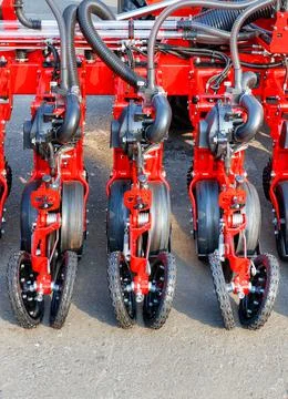 A fragment of a multi-row modern red seeder used in the agricultural sector. Stock Photos