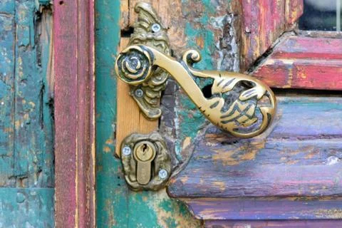 Fragment of an old, scratched, multi-colored front door with glass and metal Stock Photos