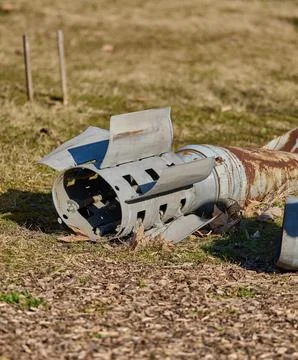 Fragment of a rocket or cluster submunition tail section on the ground. Stock Photos