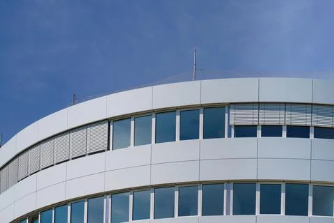 Fragment of a semicircular building against a blue sky. Stock Photos