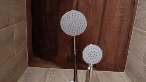 Fragment of a shower head against the background of brown ceramic tiles in the Stock Footage 335639969