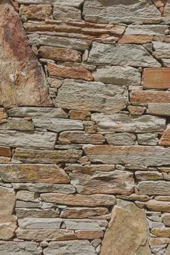 A fragment of a stone wall built without the use of cement. Backround for des Stock Photos
