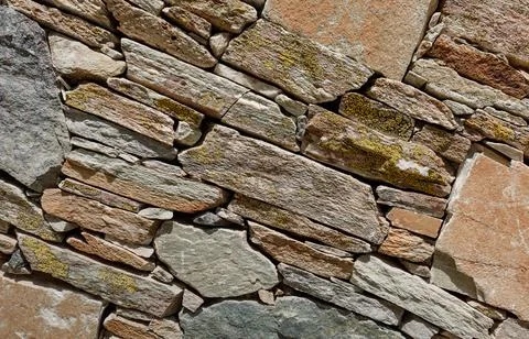 A fragment of a stone wall built without the use of cement. Backround for des Stock Photos