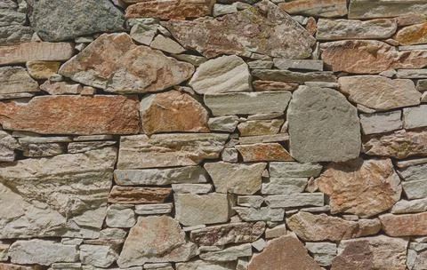 A fragment of a stone wall built without the use of cement. Backround for des Stock Photos