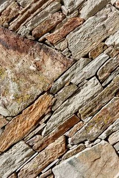 A fragment of a stone wall built without the use of cement. Backround for des Stock Photos