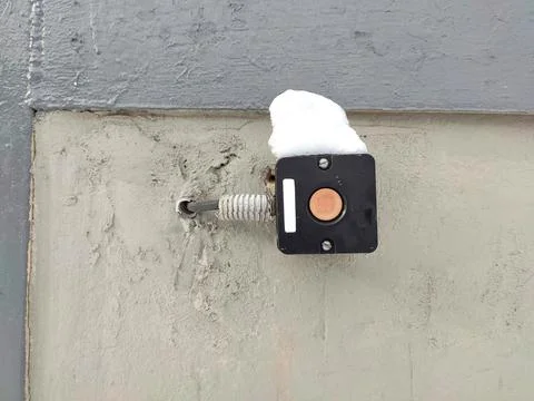 Fragment of a wall with a black button for opening the gate Stock Photos