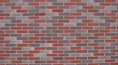 A fragment of a wall built from bricks of grey and red shades. Stock-Fotos