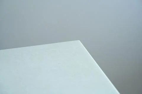 Fragment of a white table on a gray background Stock Photos