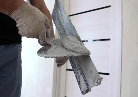 Fragment of the work of a plasterer with two spatulas Stock Photos