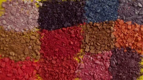 The fragmentation of eye shadow is scattered on a yellow surface. Stock Footage 77580845