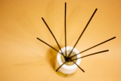 Fragrance diffuser perfume freshener black sticks on brown background flatly. Stock Photos
