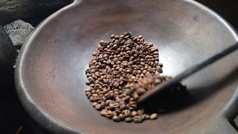 Fragrant coffee beans are roasted in a frying pan, smoke comes from coffee beans Stock Footage 122565831