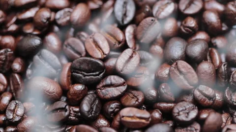 Fragrant coffee beans are roasted and the smoke covers the beans from roasting Video stock 231594281