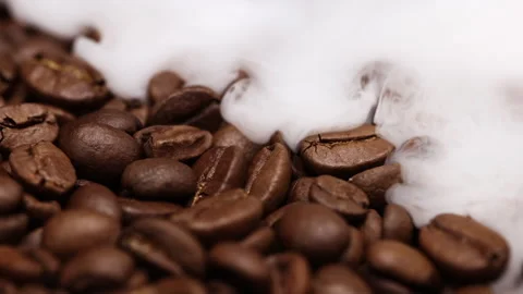 Fragrant coffee beans are roasted in a frying pan, smoke comes from coffee beans Stock Footage 260409825
