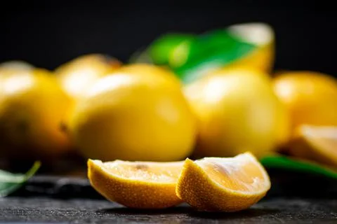Fragrant lemons with leaves on the table. Stock Photos