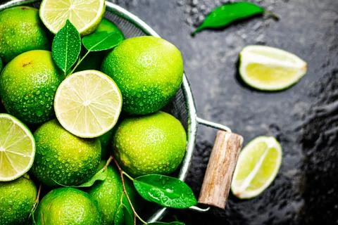 Fragrant lime with leaves in a colander. Stock Photos