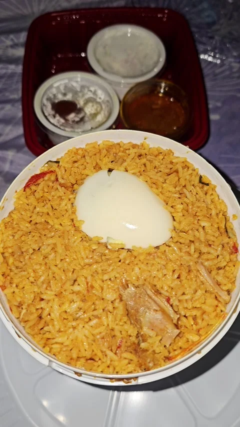 Fragrant mutton bucket biryani served with a boiled egg, packed with aromatic 스톡 동영상 346978401