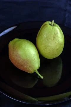 Fragrant pears fruit on black dish Stock Photos