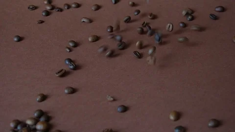 Fragrant roasted coffee beans fall on the table Stock Footage 114904968