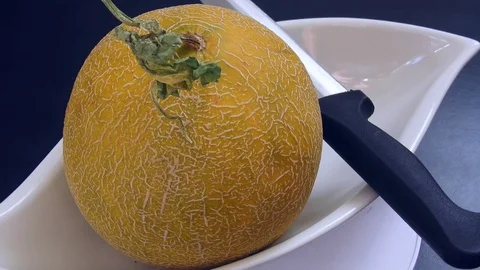 Fragrant stands on a black background with a whole melon and knife, 動画素材 129856715