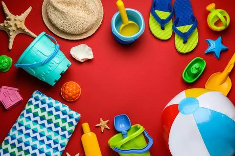 Frame of beach ball and sand toys on red background, flat lay. Space for text 写真素材