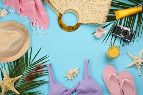 Frame of beach objects on light blue background, flat lay. Space for text Stock Photos