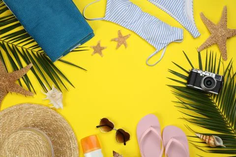 Frame of beach objects on yellow background, flat lay. Space for text Stock Photos
