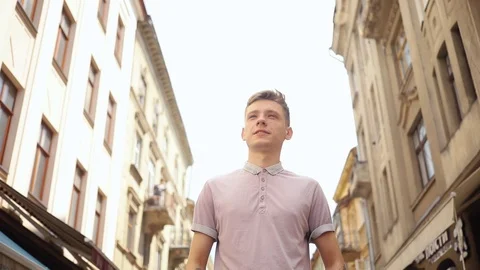 Frame from below smiling handsoman man walk on street speak on phone happy Stock Footage 92430173