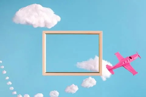 Frame on blue background with abstract clouds and pink airplane Stock Photos