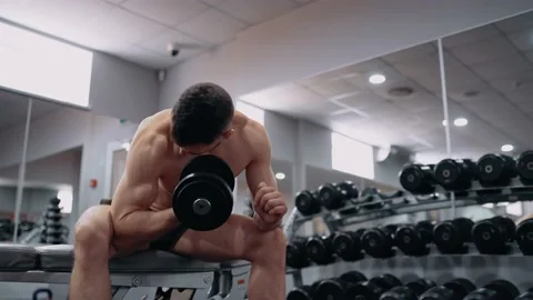 The frame of a bodybuilder who performs, sitting, exercise for the muscles of Stock-Footage 156855832