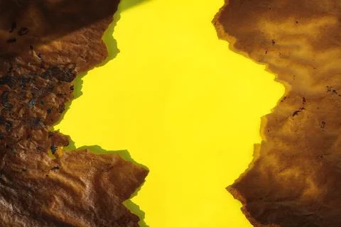 Frame brown torn baking paper and yellow background Stock Photos