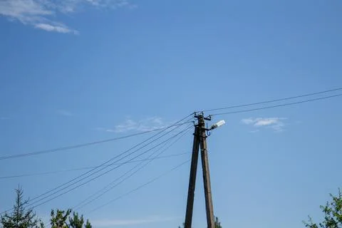 A-frame concrete utility pole with electrical wires and street lamp Stock Photos